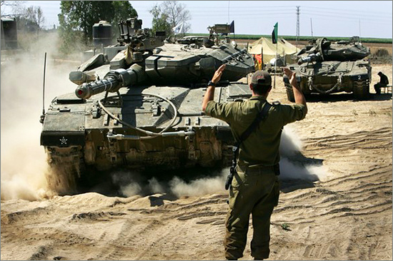 An Israeli soldier directs a Merkava tank onto a flatbed truck in an army camp Israeli-Troops1.jpg
