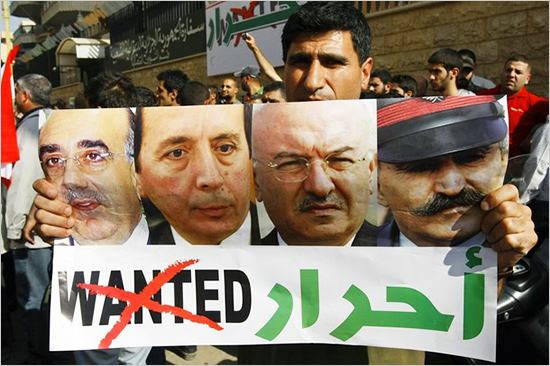 A man carries a poster with the pictures of released Lebanese generals, with the word false_flag_siria_550.jpg