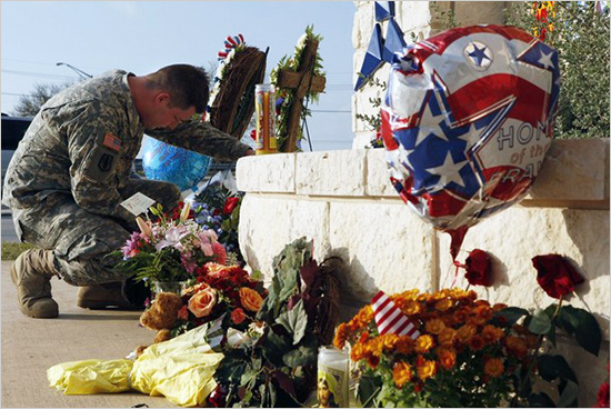 United States Army Specialist Robert Orcutt prays near a makeshift memorial for victims of the shootings at Fort Hood Army post in Fort Hood, Texas November 9, 2009 usa_ammutinamento_550.jpg