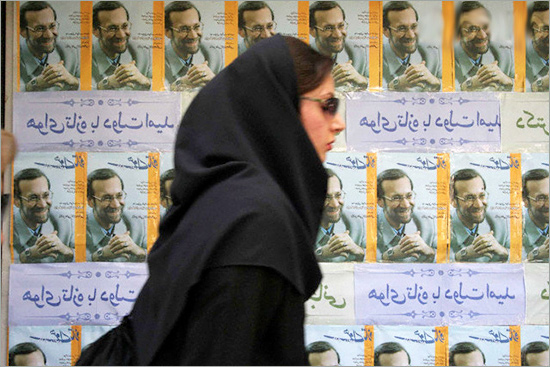 An Iranian woman passes by a portrait of Ali Larijani iran_el.jpg