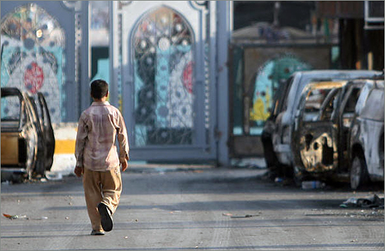 Karbala city: a boy walks past burned cars where 52 people were killed iraqi_bush.jpg