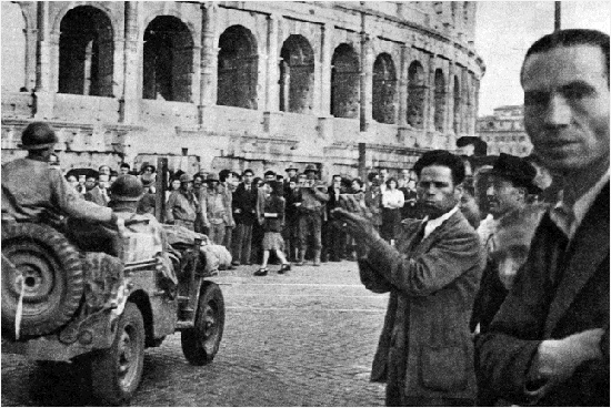 automezzi americani transitano nei pressi del Colosseo salutati dalla popolazione e dalle truppe entrate da poco. liberazione_550.jpg