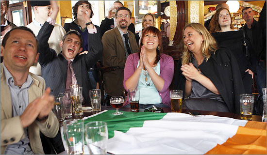 Opponents of the treaty applauding as they watch the results of the Irish referendum on the Lisbon Treaty in a pub near the EU Commission headquarters in Brussels on Friday. (Francois Lenoir/Reuters) no_vote.jpg
