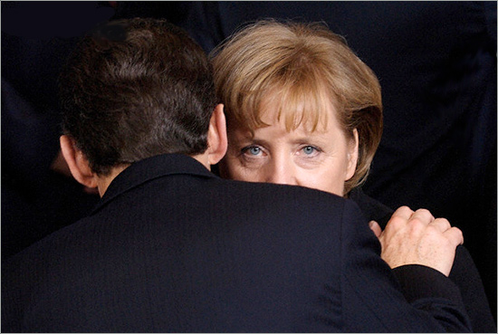 Angela Merkel, Germany's chancellor, (R), talks with Nicolas Sarkozy, French President, as European heads of state gather for a group portrait during the European Summit, Brussels. European leaders are meeting for a two-day summit in Brussels, to discuss how to revive their economies, stop global warming and bring their Mediterranean neighbours closer together. High on the official agenda is how to make the European economy more competitive in the midst of a global slowdown. sar_mer.jpg